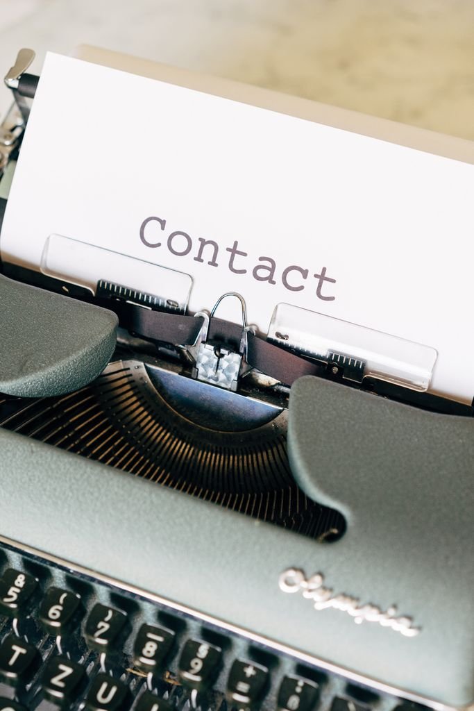 A close-up of a vintage typewriter with paper containing the word 'Contact'.